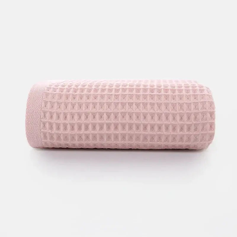 A soft pink cotton waffle towel from the soft gray blush and blue cotton waffle towel bath set by decorbites