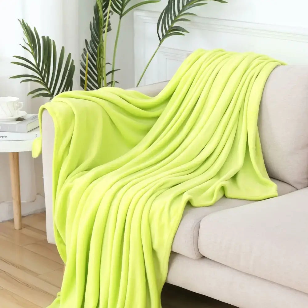 A soft gray cozy flannel warm blanket draped over a beige sofa highlighting flannel warm blanket decorbites quality