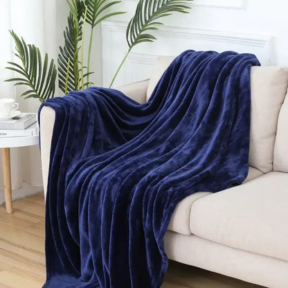A plush navy blue cozy flannel warm blanket with soft velvety texture draped over a beige sofa for decorbites cozy flannel