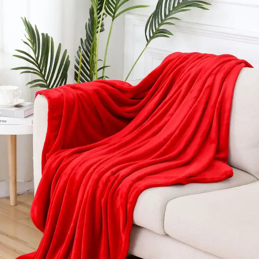 Vibrant red plush throw blanket draped over white sofa showcasing decorbites cozy flannel warm bedroom shawl