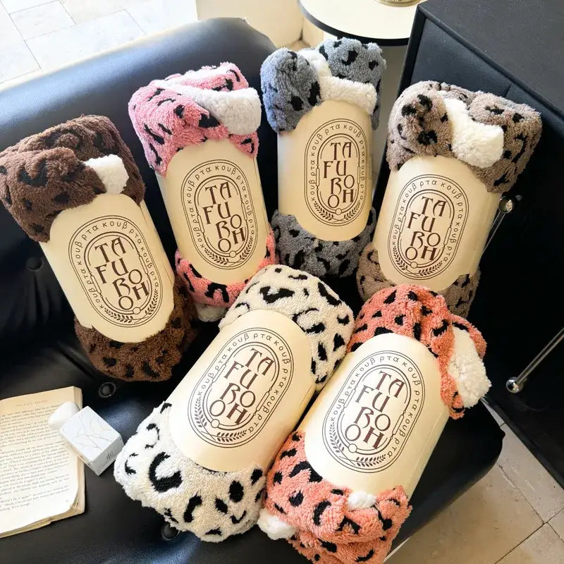 Soft leopard print double layered wool blanket in brown pink gray and orange wrapped around tubes with ta fu boh label