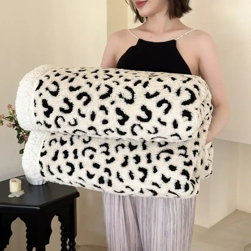 A soft cream-colored wool blanket with black decorbites leopard print double layered design for bedroom throw