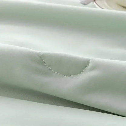 Soft mint green decorbites cooling quilt with subtle sheen and delicate curved stitching for bedroom comfort