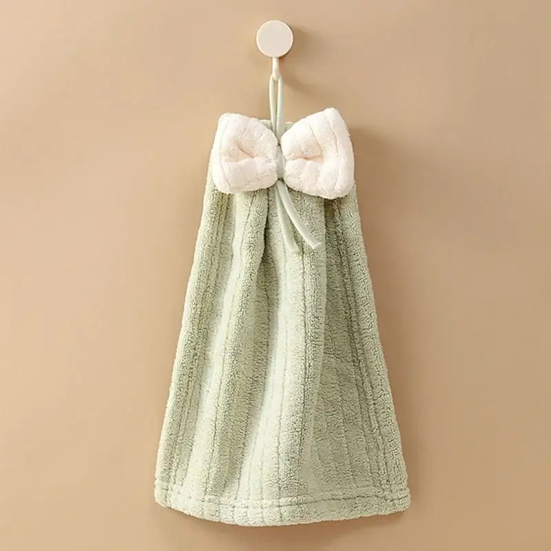 A soft mint green hand towel with a plush white bowknot made of decorbites bowknot microfiber for kitchen and bathroom use