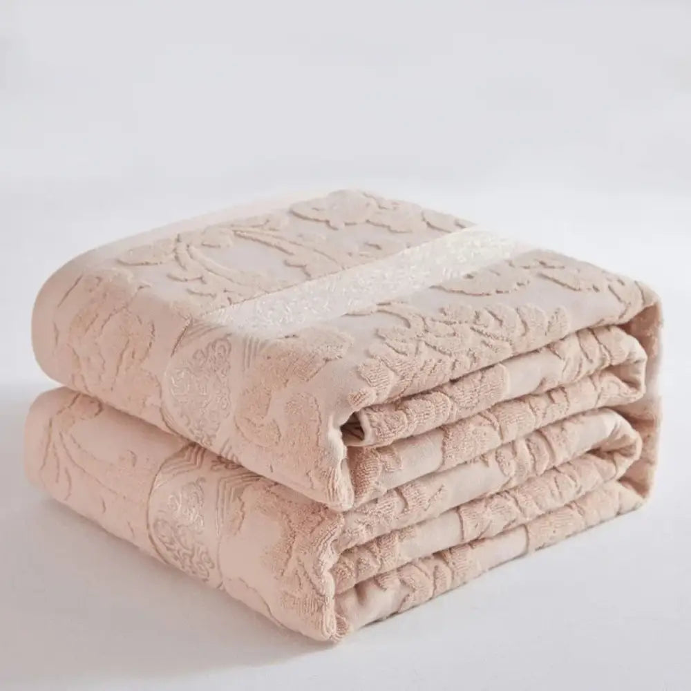 Soft pastel cotton jacquard towel blanket in blush pink with embroidered floral pattern and subtle shimmering stripe