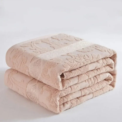 Soft pastel cotton jacquard towel blanket in blush pink with embroidered floral pattern and subtle shimmering stripe