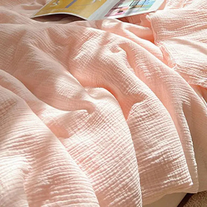 Soft pink cotton muslin blanket with subtle crinkled texture featuring decorbites cooling wrinkled yarn design
