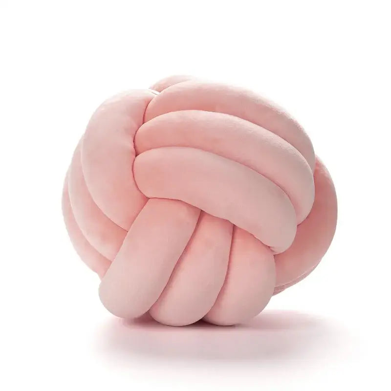 Soft pink velvet knotted ball round pillow made of plush fabric for elegant bedroom decor