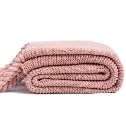 Soft pink decorbites knit throw blanket with ribbed texture and braided tassel accents for bedroom decor