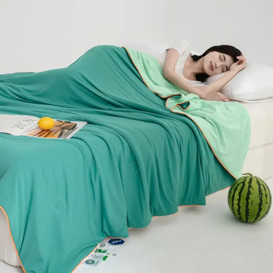 Soft teal and gold decorbites cool fibre summer quilt draped over a sleeping woman for a cool fibre summer bedroom blanket