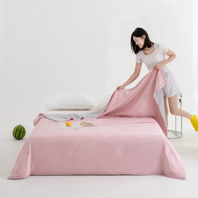Soft pink satin bedsheet with gentle folds paired with decorbites cool fibre summer quilt in teal and gold colors