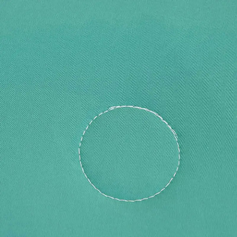 A white circular stitch detail on a soft teal and gold decorbites cool fibre summer quilt bedroom blanket