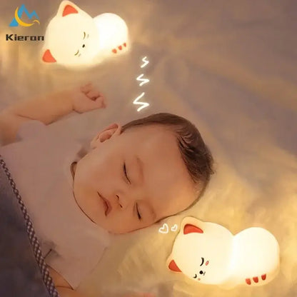 Soft white cat led night light with red silicone details softly glowing above a sleeping baby for bedroom decorbites cat led use