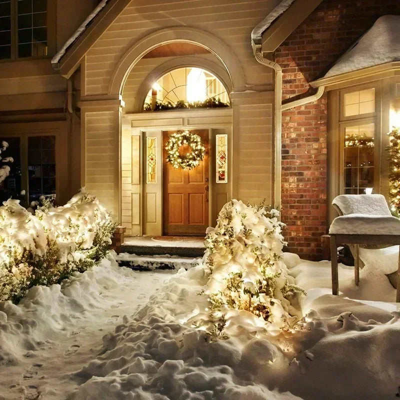 Warmly lit wooden front door decorated with festive wreath and solar fairy string light outdoor waterproof led lights