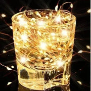 Golden solar fairy light string wrapped in a clear glass tumbler showcasing warm waterproof outdoor led lights