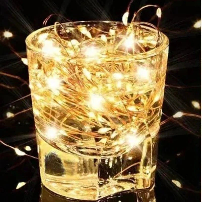 Golden solar fairy light string wrapped in a clear glass tumbler showcasing warm waterproof outdoor led lights