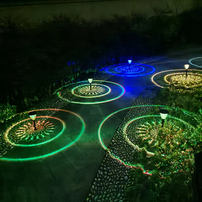 Colorful outdoor waterproof solar powered LED garden path lights casting green blue and yellow circular radiant patterns
