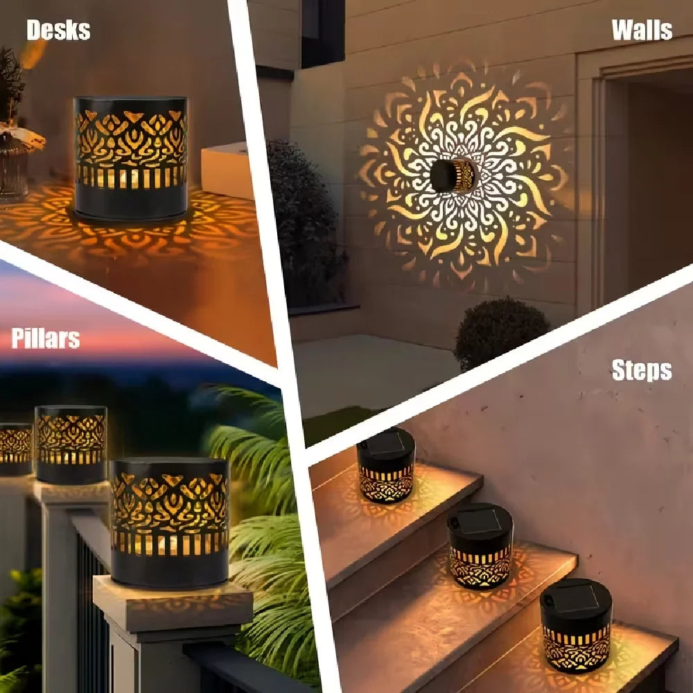 Black cylindrical solar mandala projection light with gold-toned cutout patterns casting decorative illumination outdoors