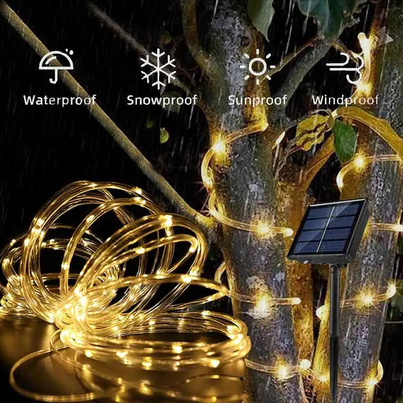 Golden solar rope lights with warm glowing led bulbs wrapped around tree trunk for outdoor garden and deck lighting