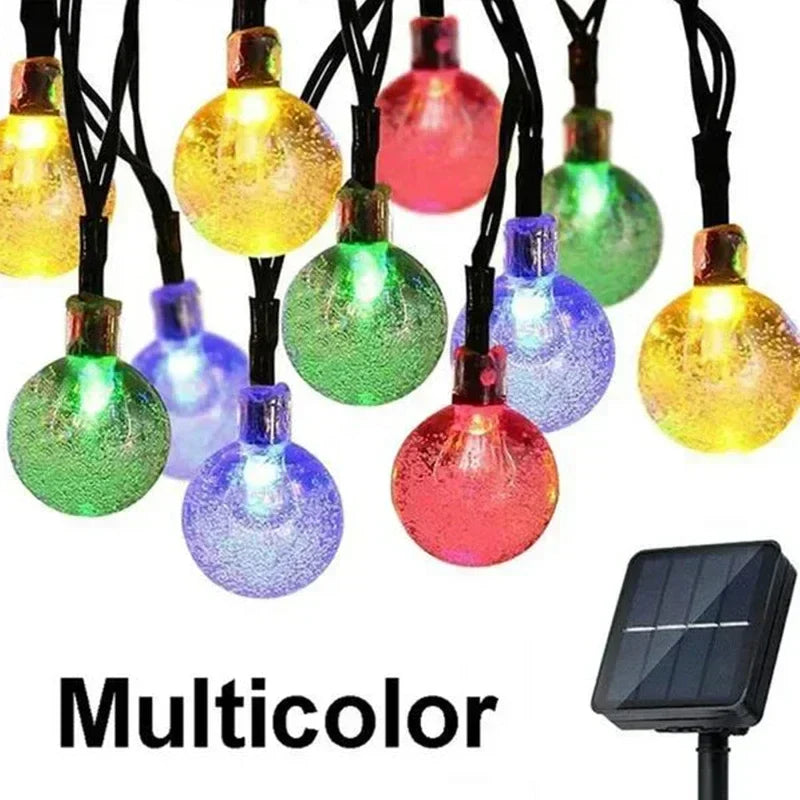Multicolor solar-powered outdoor string lights with frosted glass globe bulbs in assorted hues for garden decor