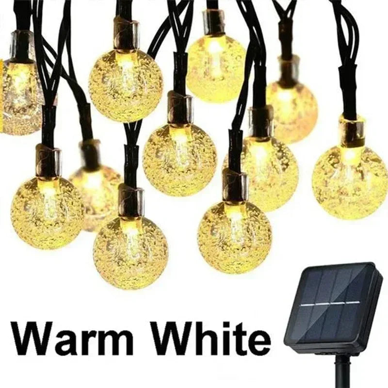 Warm white solar string lights with crackled glass globe bulbs and black wiring for outdoor garden party decor