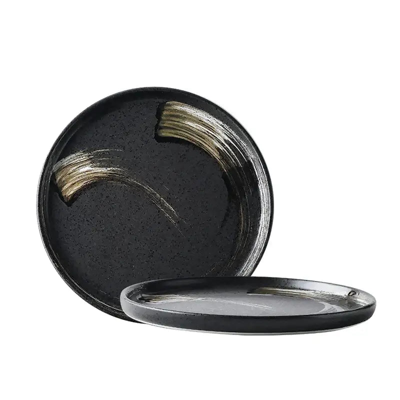 Black ceramic round dinner plate with elegant gold brushstroke accents from decorbites ceramic round collection