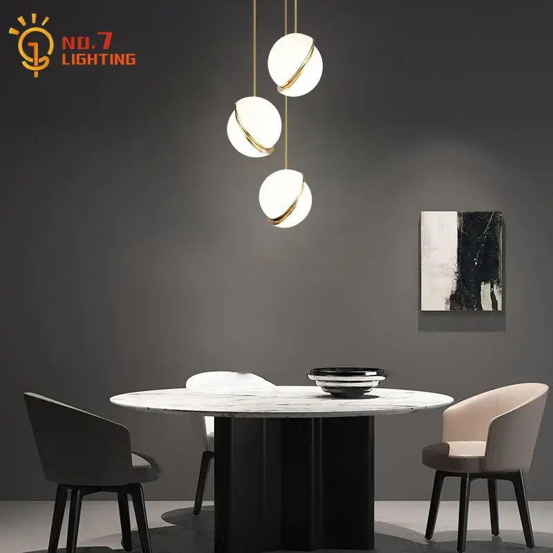 Modern pendant lights featuring three spherical white glass shades with gold lustre led accents on brass chains for living room decorbites gold lustre design