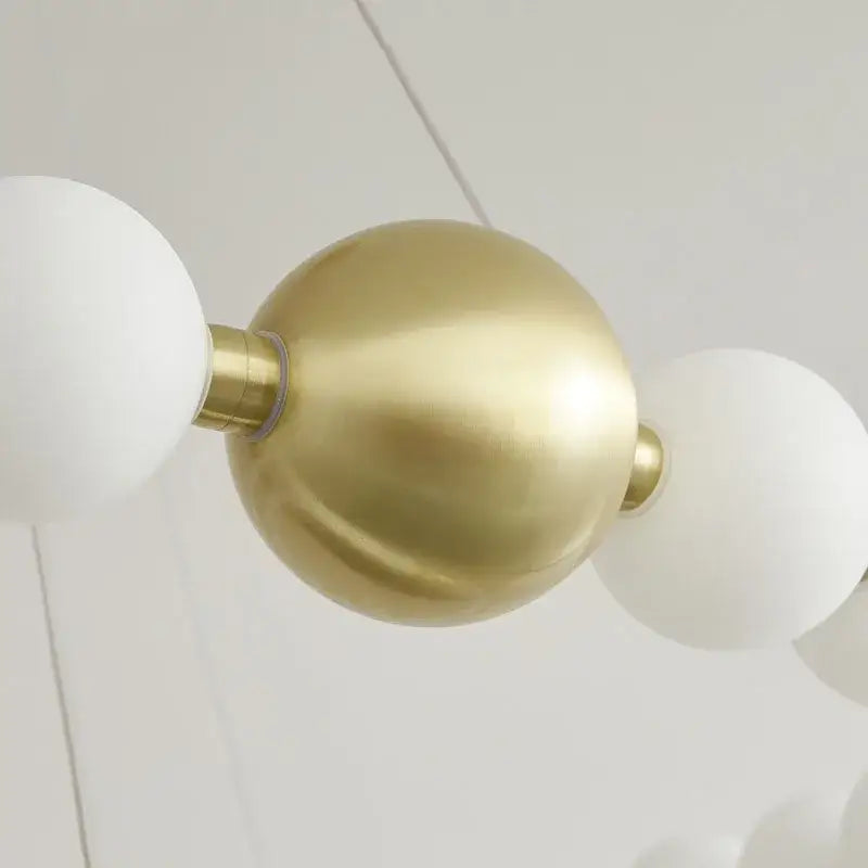 Spiral brass led chandelier featuring brass spherical pendant lights with frosted white glass globes for dining room decorbites brass led