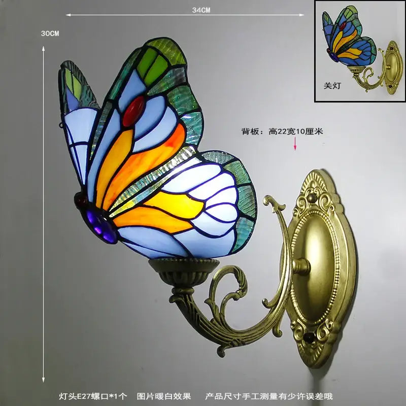 Stained glass butterfly wall sconces with vibrant blue orange yellow green wings on ornate gold metalwork bracket decorbites butterfly stained