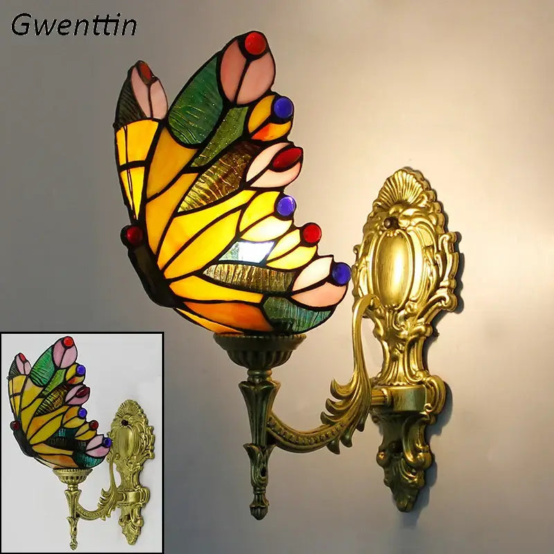 A vibrant stained glass butterfly wall sconce with yellow green pink and blue segments in a gold metal frame decorbites butterfly stained