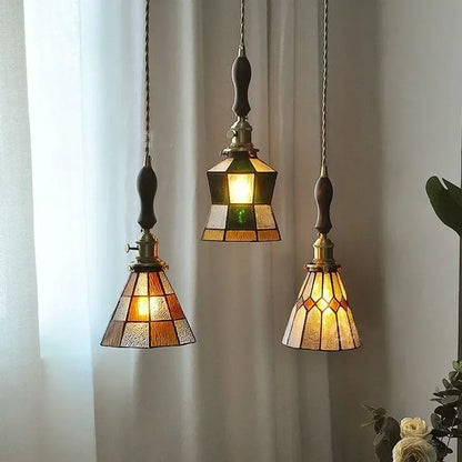 Three vintage-style stained glass pendant lights with warm amber and green hues featuring colorful glass copper finish