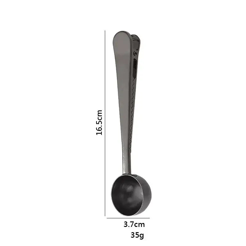 A sleek matte black stainless steel coffee spoon with a clip-on handle and sealing clip for kitchen use