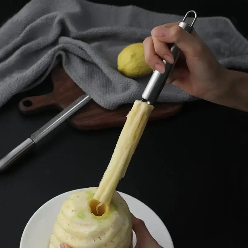 Silver stainless steel decorbites fruit corer with looped handle peeling skin from fruit in kitchen use
