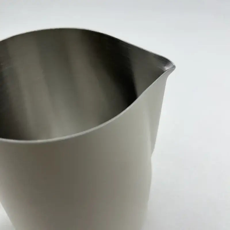 Stainless steel milk frothing jug with brushed finish and curved spout perfect for precise milk frothing