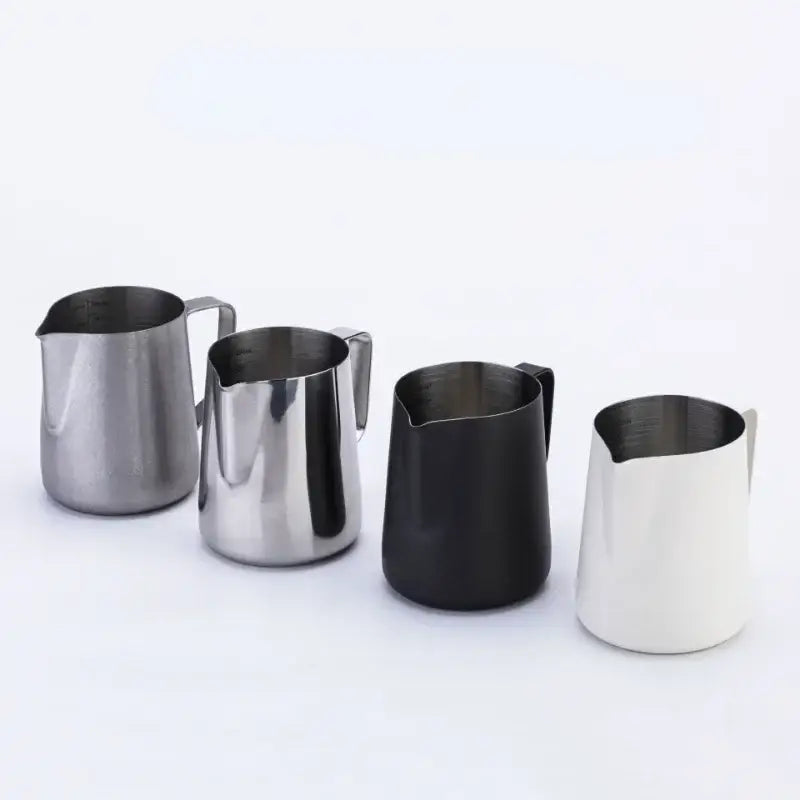 Four stainless steel milk frothing jugs in polished silver matte black and white finishes with measurements