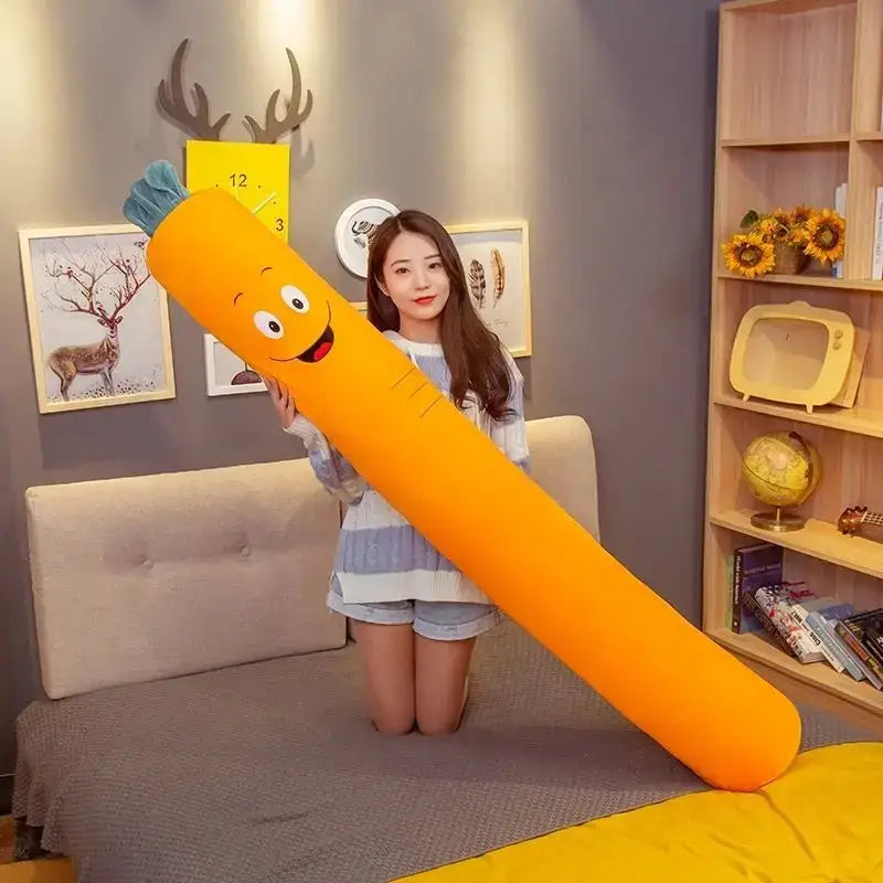 A plush bright orange carrot-shaped soft pregnancy sleep pillow with a smiling face and green leafy top decorbites cylindrical