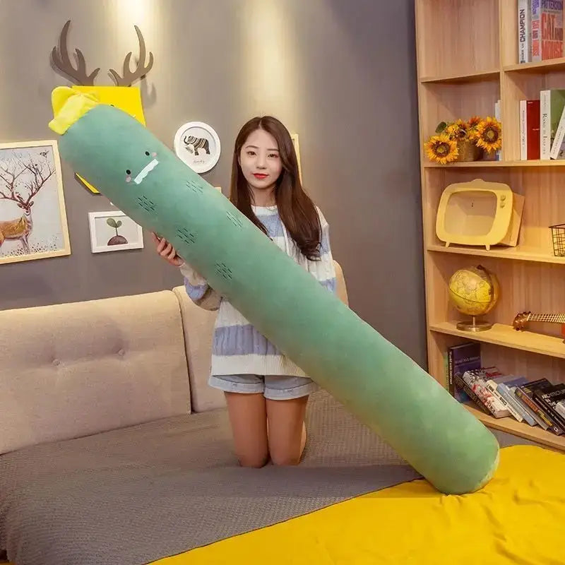 Decorbites cylindrical soft pregnancy sleep pillow in green plush shaped like a cucumber with yellow tip and face embroidery