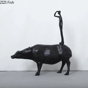 Stylized black matte metal cowherd shepherd boy sculpture standing atop a water buffalo for living room decorbites decor