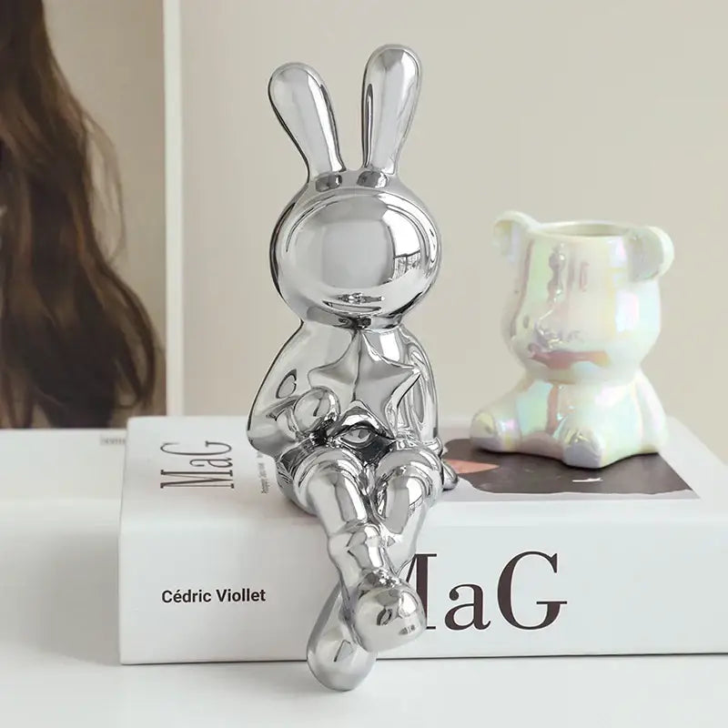 Stylized gold ceramic rabbit sculpture set featuring a shiny chrome rabbit sculpture with a sleek reflective surface