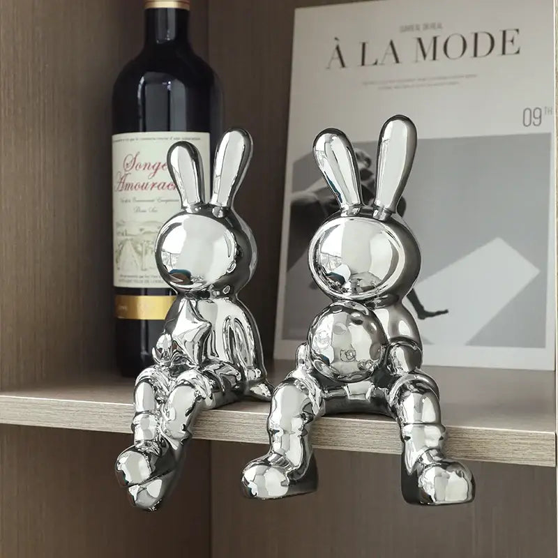 Two shiny silver ceramic rabbit sculpture set with reflective surfaces and geometric designs for living room decor