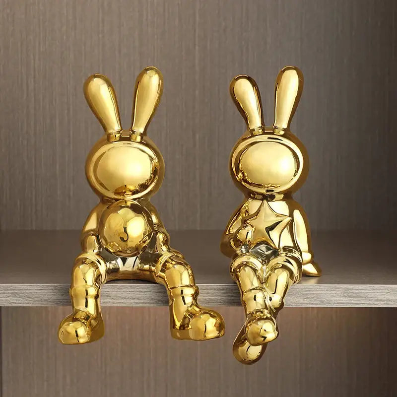 Stylized gold ceramic rabbit sculpture set featuring two glossy figurines one holding a star ornament for living room decor