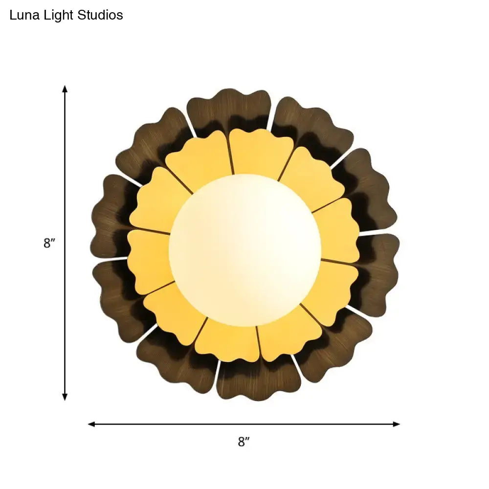Eight-inch round sunflower-themed wall sconce with layered yellow and dark brown petals and matte white glass ball