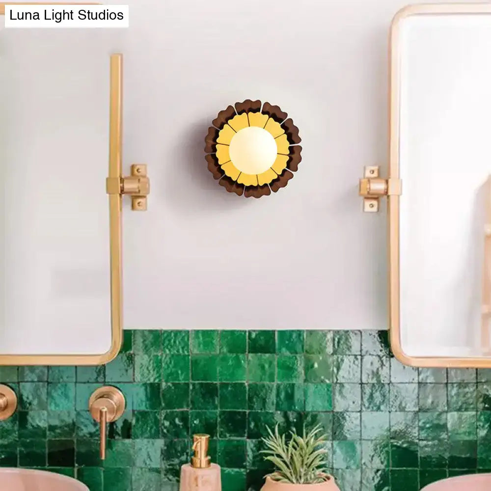 A sunflower yellow and wood wall sconce with matte white glass ball and layered petals for bedroom lighting