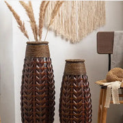 Two tall dark brown bamboo woven vases with herringbone pattern and rope-wrapped necks for living room decor