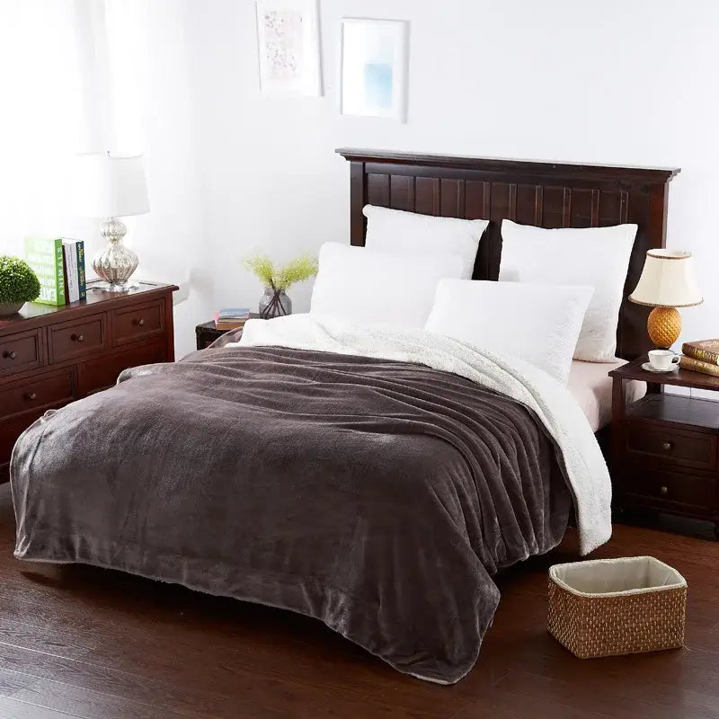 Plush dark gray and white sherpa throw blanket draped over bed featuring decorbites cozy lambswool flannel texture