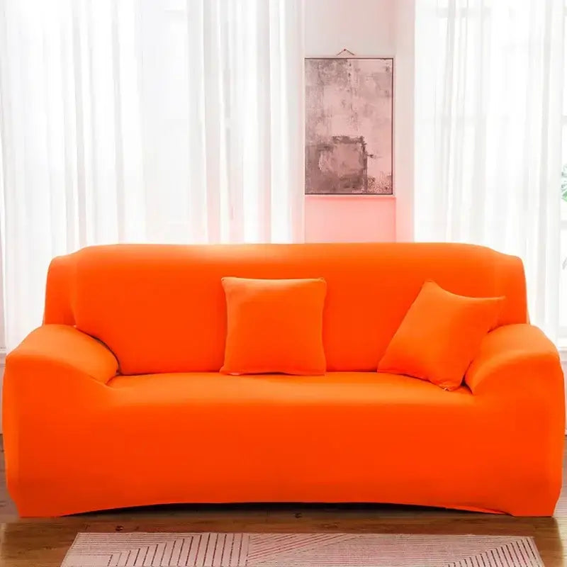 Tan stretchy silk sofa cover in bright orange snugly fits three-seater couch with matching pillows for living room accent chairs