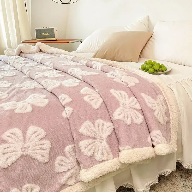 Pink plush fleece throw blanket with white embroidered bows and soft border complementing decorbites butterfly jacquard wool blanket