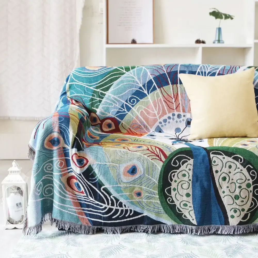 Teal and blue peacock knit sofa blanket cover with vibrant woven feather design and fringed edges for decorbites knit sofa