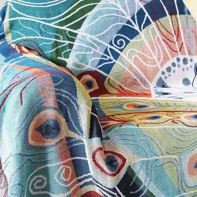 A vibrant decorbites knit sofa blanket cover with teal and blue peacock feather pattern for living room decor