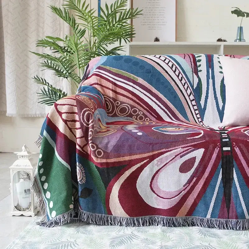 Teal and blue peacock decorbites knit sofa blanket cover with multicolored geometric patterns and fringe edges
